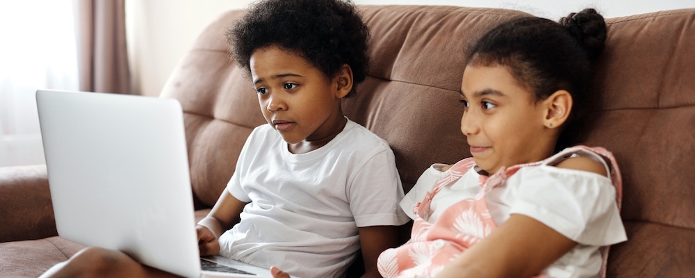 Two children watching a screen together.