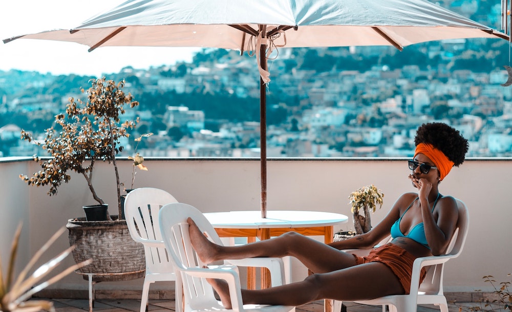 A woman relaxes under an umbrella.